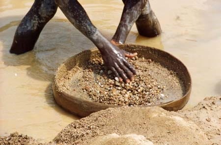 A man sifting for diamonds in a river