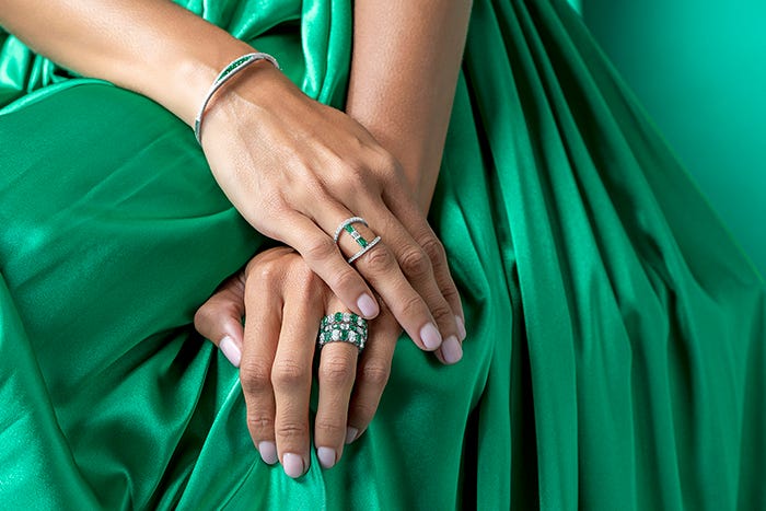 hands wearing emeralds