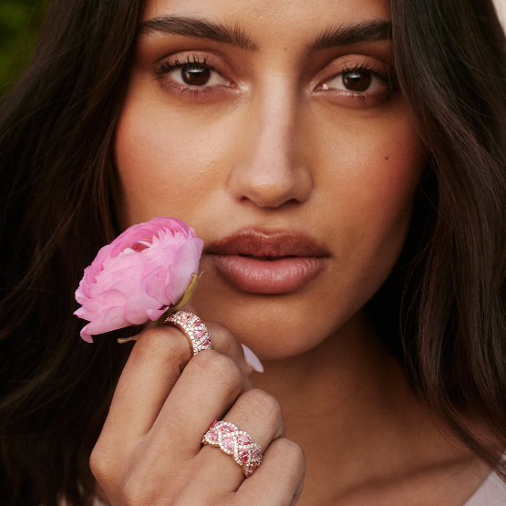 woman wearing rings and holding pink flower